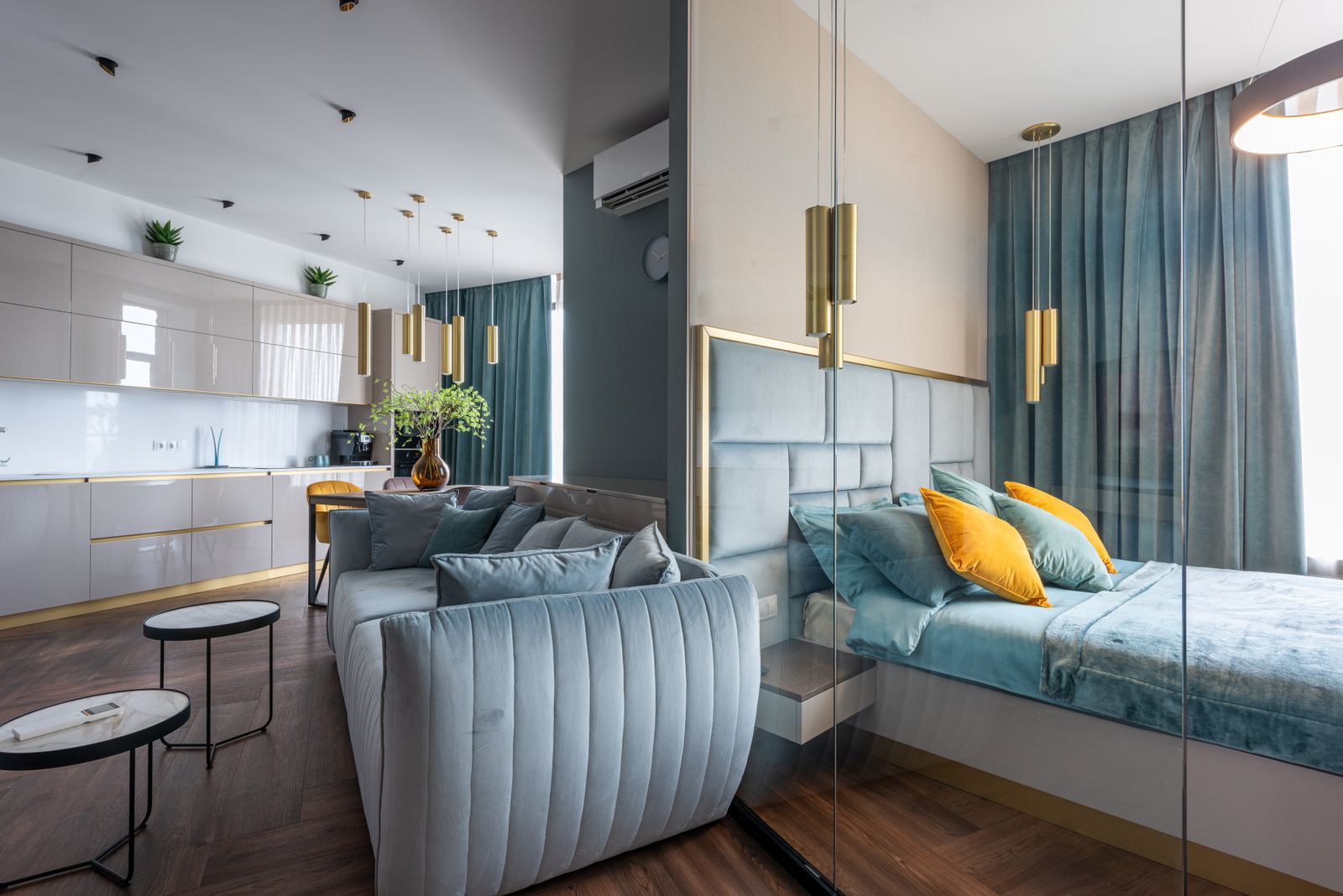 Intérieur d'un appartement meublé avec canapé, cuisine équipée et documents fiscaux, lumière douce